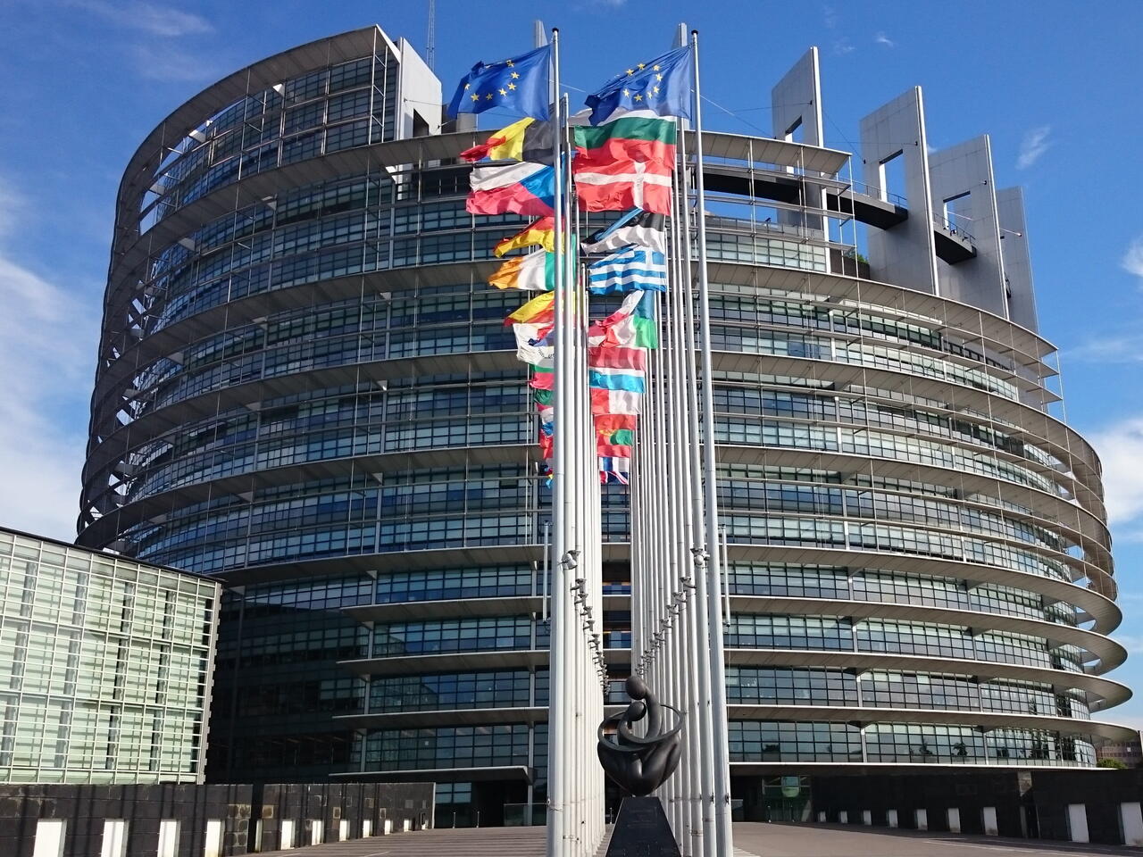 Het Europees Parlement met vlaggen van de lidstaten aan de straatkant